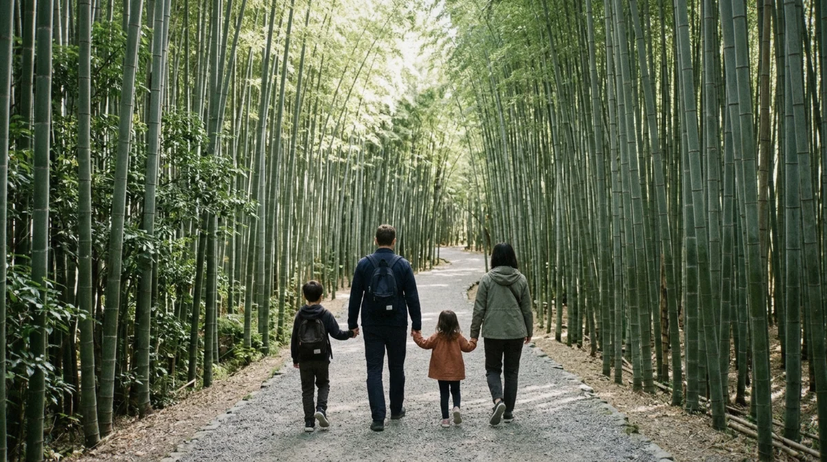 A family with young children walking the gravel path through the Arashiyama Bamboo Forest in Kyoto on a bright morning
